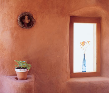 Part of the solar design, the windows in this cob community building are reclaimed from the landfill, provided by the ReBuilding Center of Our United Villages in Portland.